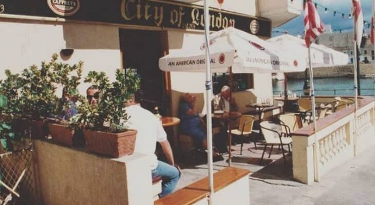 An old picture of City of London bar in Malta with people sitting outside