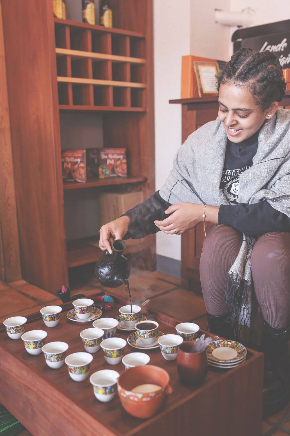 a woman pouring ethiopian coffee